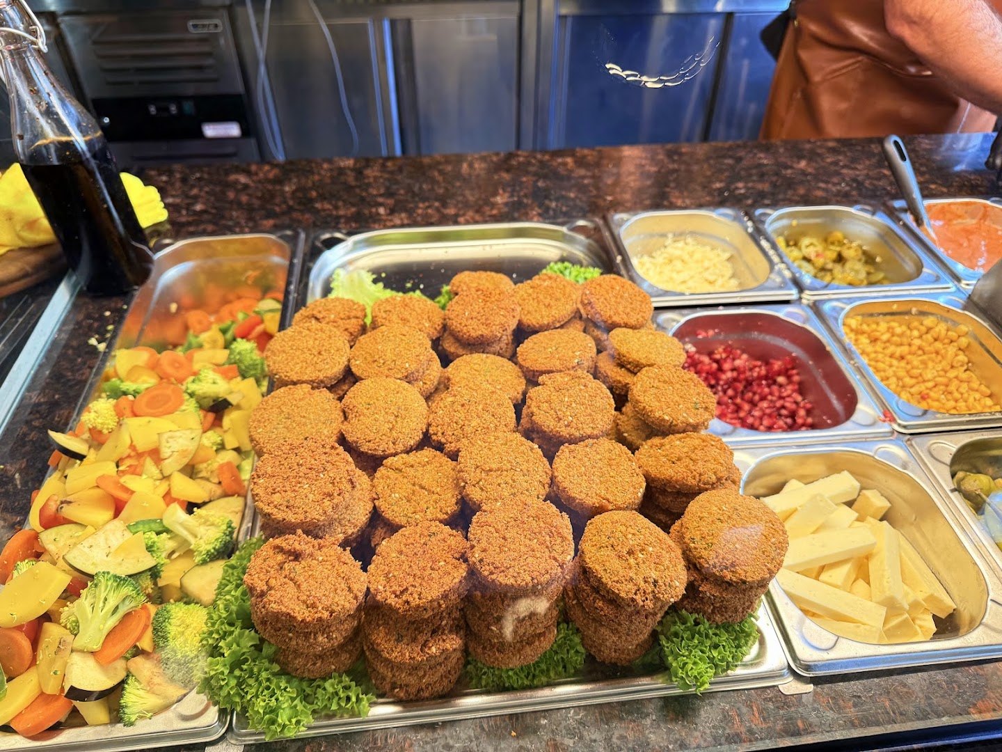 Frische Falafel in der Theke neben Salat und Gemüse