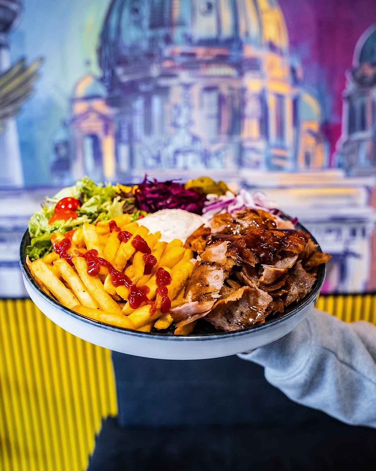 Teller mit Fleisch, Pommes, Salat und Soße